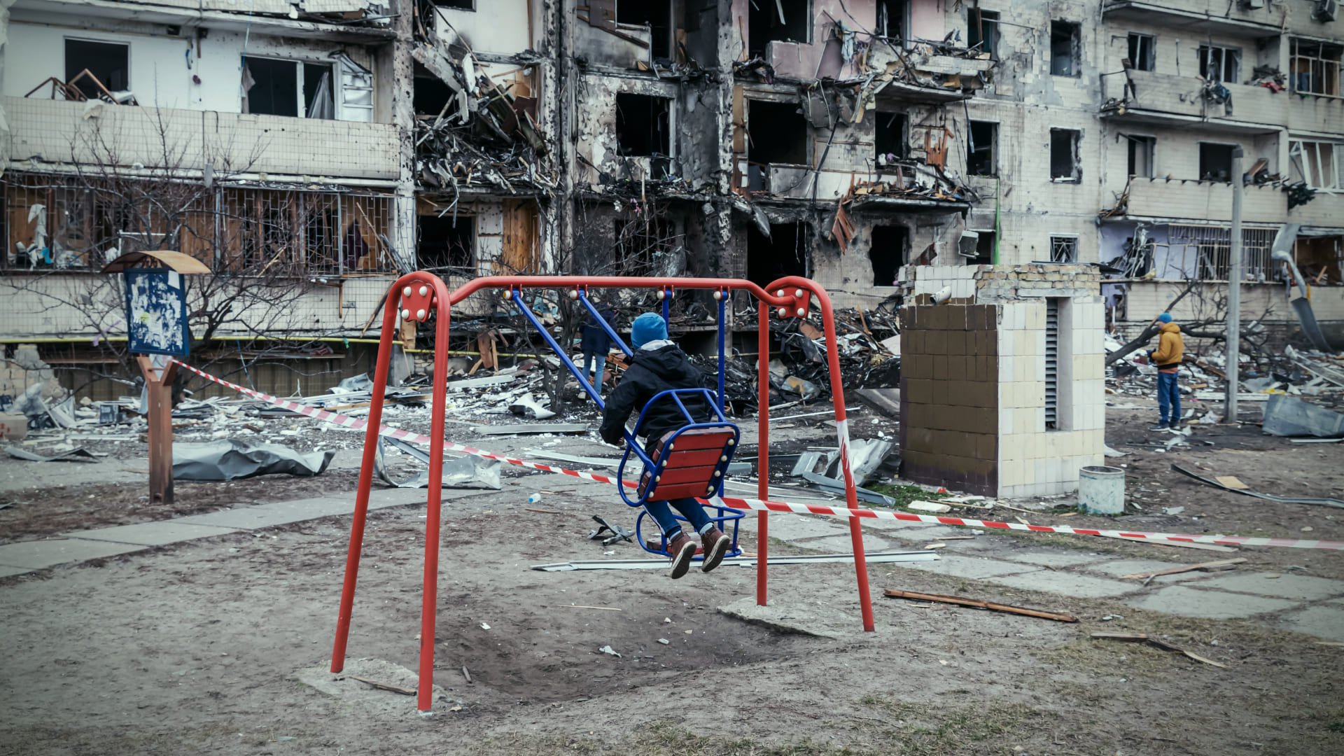 基辅，2022 年 2 月 25 日：孩子在一栋被俄罗斯火箭损坏的住宅楼前荡秋千。照片：WePlay Holding